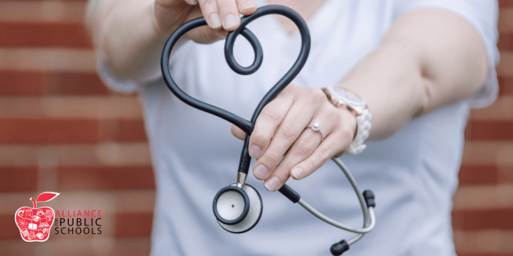 photo of nurse holding stethascope in the shape of a heart